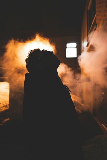A person standing in front of a building with smoke coming out of it (Jean-Daniel Francoeur, free download)